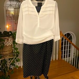 Black pencil skirt to the knee with white polkadots and back slit, size 18.